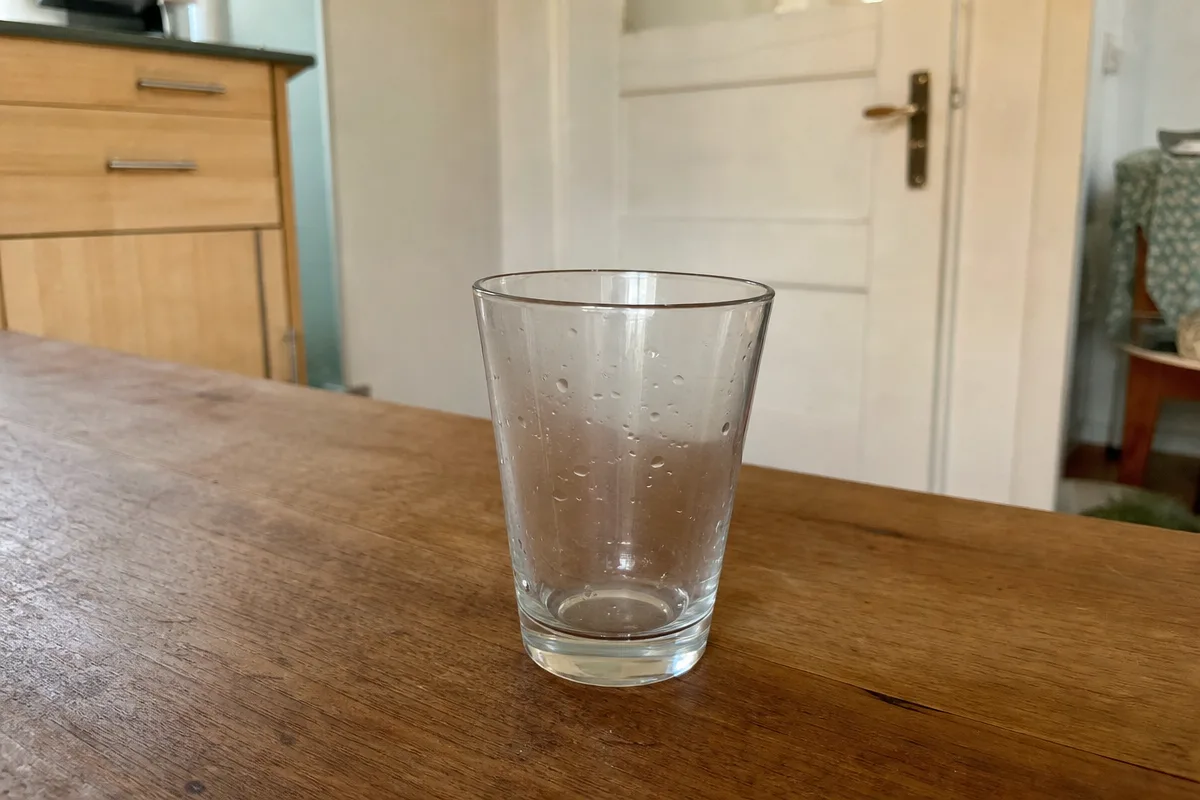 Ein leeres Wasserglas auf dem Küchentisch